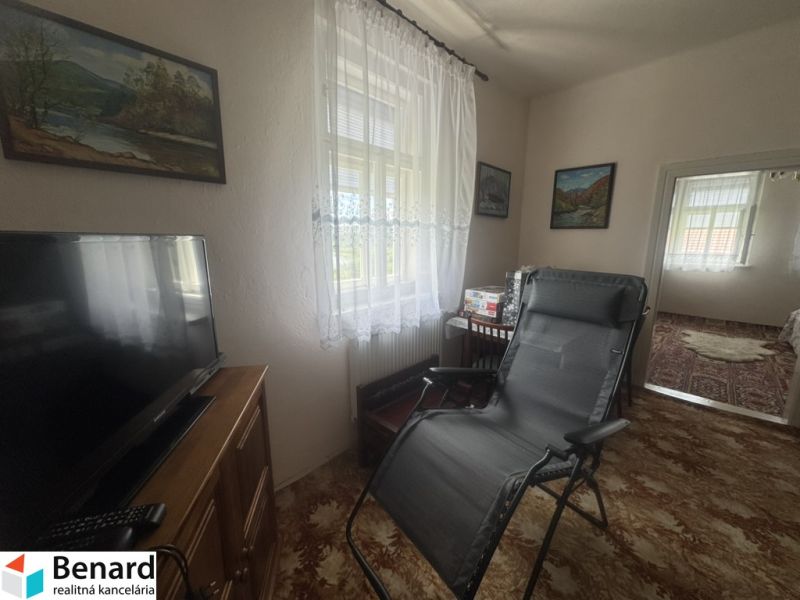 Living room in a family house with a TV, an armchair, and decorations on the walls.