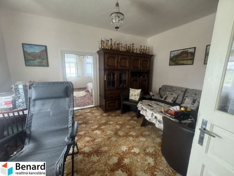 A room in a family house with a richly decorated cabinet and comfortable seating.