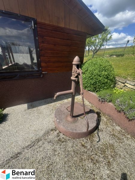 A family house in Orlov with an old water pump on a gravel base.