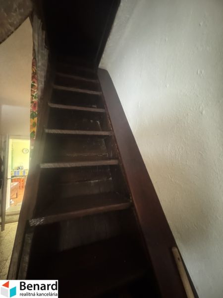 A staircase leading up in a family house with dark wooden steps.