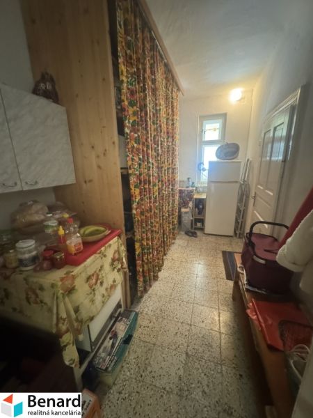 A hallway in a family house with colorful curtains and kitchen furniture.