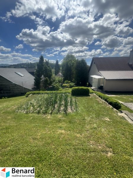 A garden with a lawn and a view of the surroundings in Orlov near family houses.