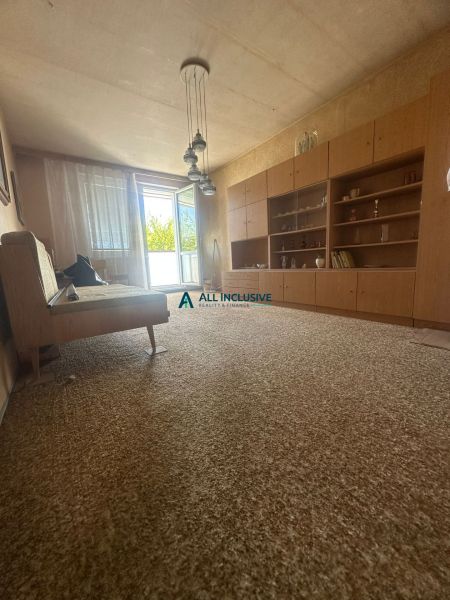 Living room in a two-room apartment with open balcony doors and retro furniture.