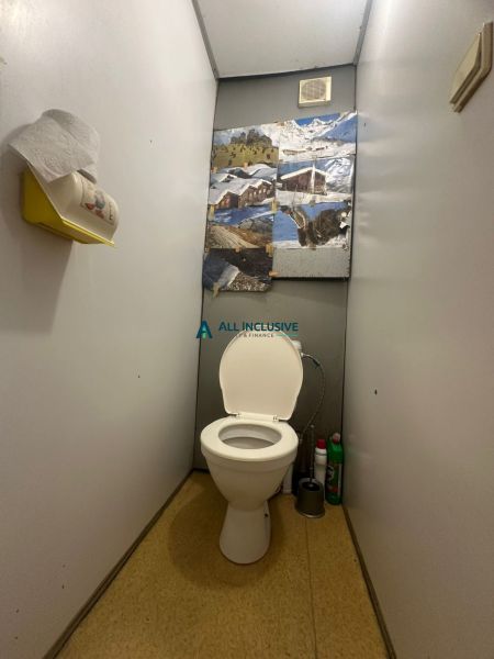 A toilet with wall decoration and storage space in a 2-room apartment.