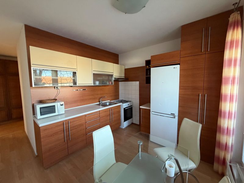 A kitchen in a 3-room apartment with a wooden decor and modern equipment.