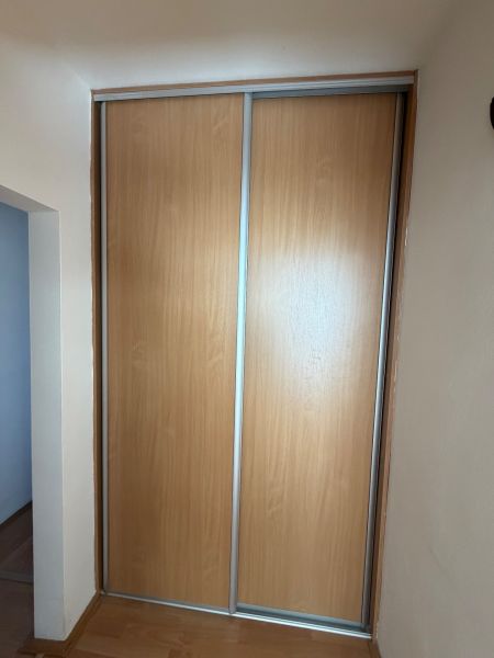 A wardrobe with sliding doors and a floor with a wooden decor in a 3-room apartment.