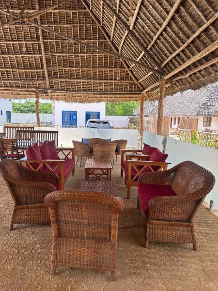 A covered terrace with rattan furniture in Zanzibar offers a family house a pleasant place to relax.