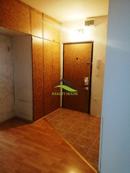 Entrance hallway with wood-patterned flooring in a 3-room apartment with wardrobe closets.