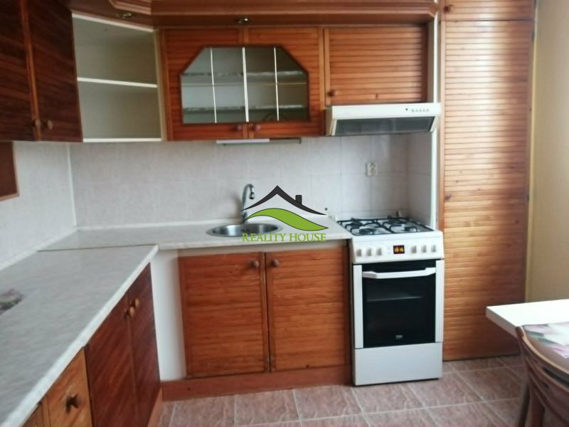 A kitchen in a 3-room apartment with a wooden decor kitchen unit.