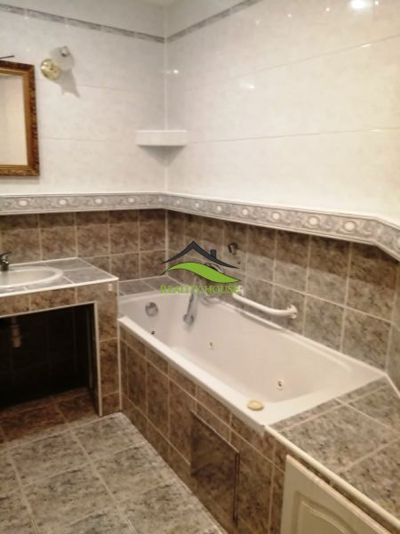 A bathroom with tiles and a bathtub in a 3-room apartment.
