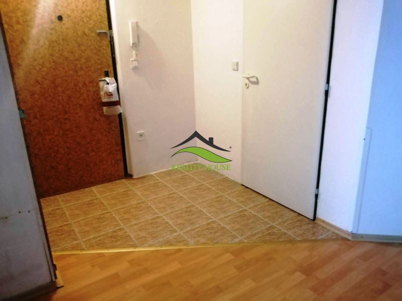 Hallway of a 3-room apartment with tiles and flooring with a wooden decor.