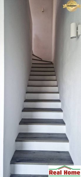 A staircase with a wooden decor floor leading upwards in a family house.