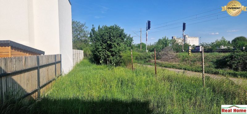 Courtyards of family houses on Hviezdoslavova Street in Senec, separated by a railway track.