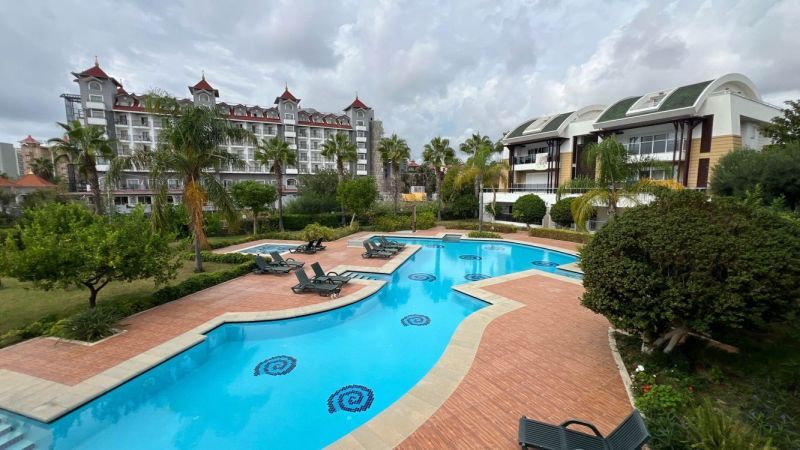 Hotel pool with palm trees and buildings in the resort of Side, Turkey, for Special Properties.
