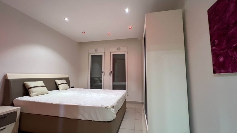 Bedroom with a double bed, white walls, and a cabinet, peculiar properties.