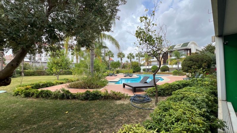 A pool surrounded by greenery and loungers in a garden in Side, Turkey, for Special Properties.