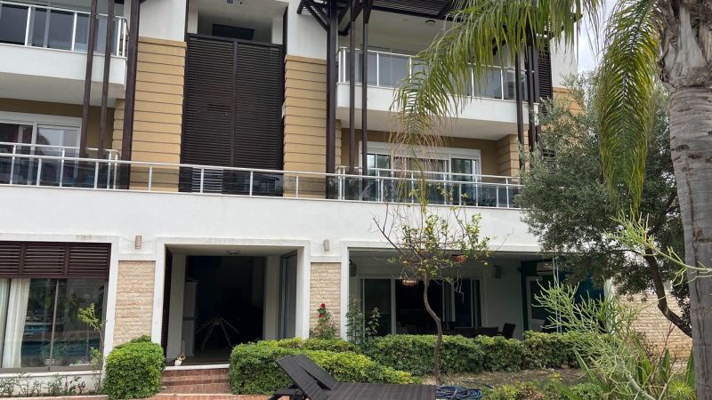 Building with glass balconies and greenery in Side, Turkey - Unique properties.