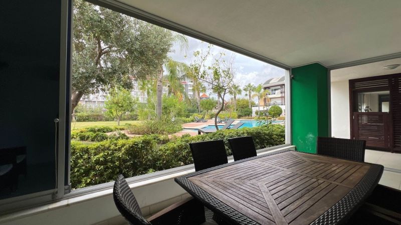 Covered terrace with garden furniture and a view of the pool in Side, Turkey.