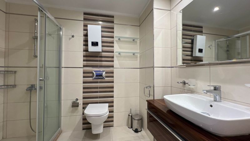 Bathroom with a shower, sink, and toilet, Unique properties.