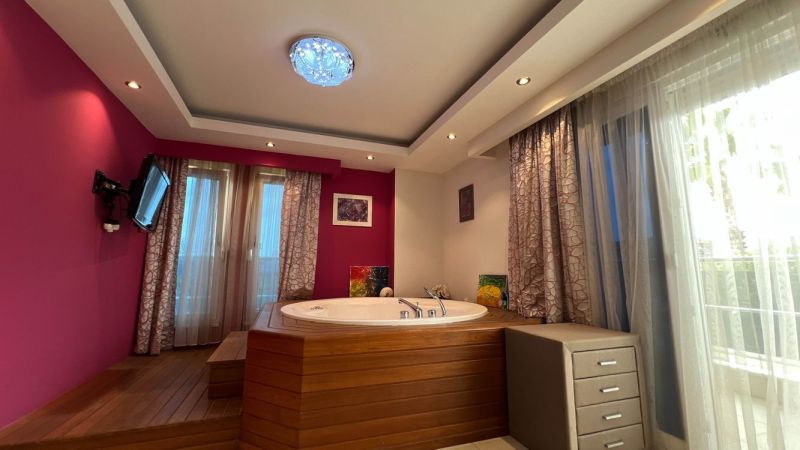 In the interior of the Special property, there is a bathtub surrounded by walls in shades of pink.
