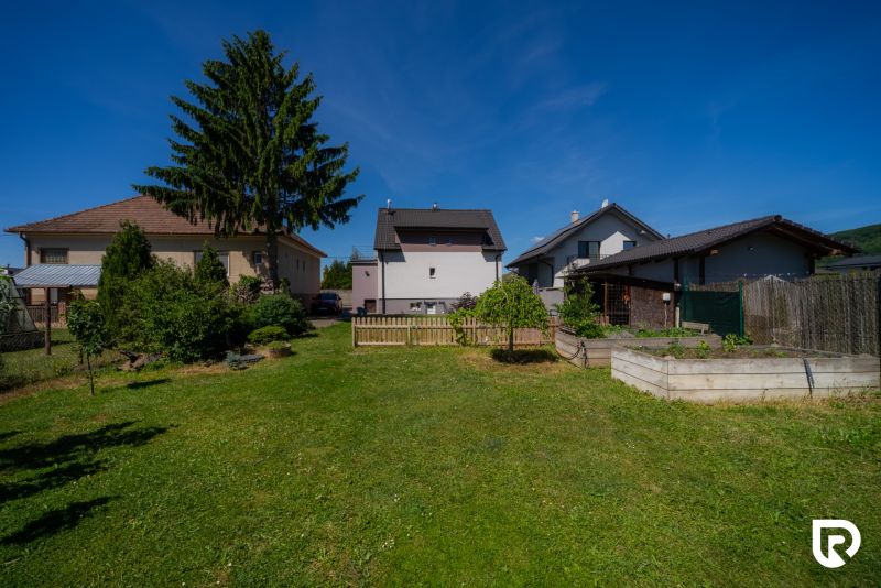 The garden of a family house on Jahodova Street in Trencin with a lawn and trees.