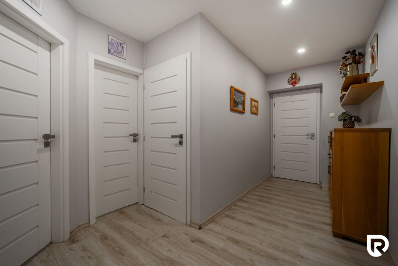 Interior of a family house with white doors and a wooden decor floor.