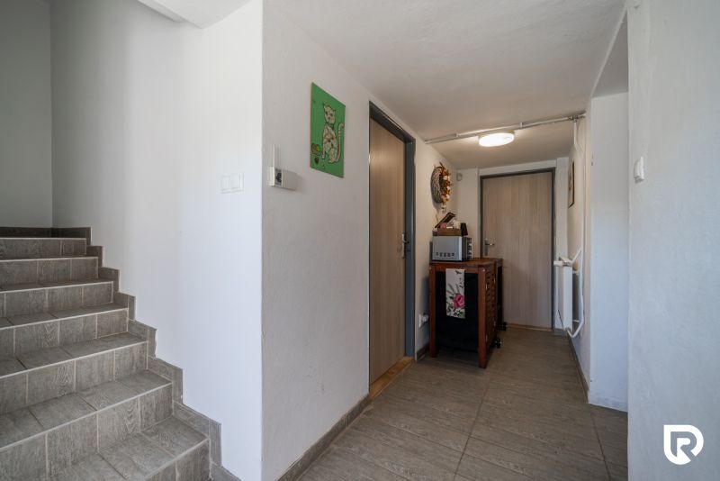 Entrance hall of a family house with a wooden decor floor and a staircase.