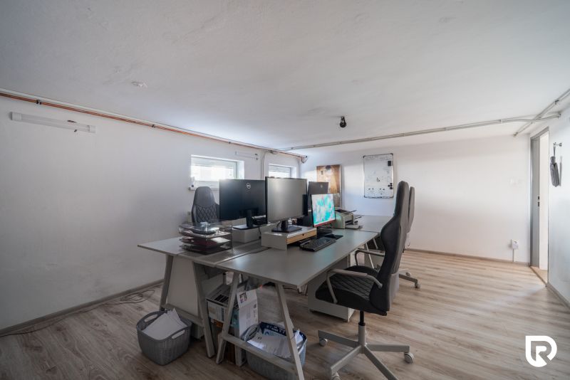 Office room in a family house with a wooden decor floor and work desks.