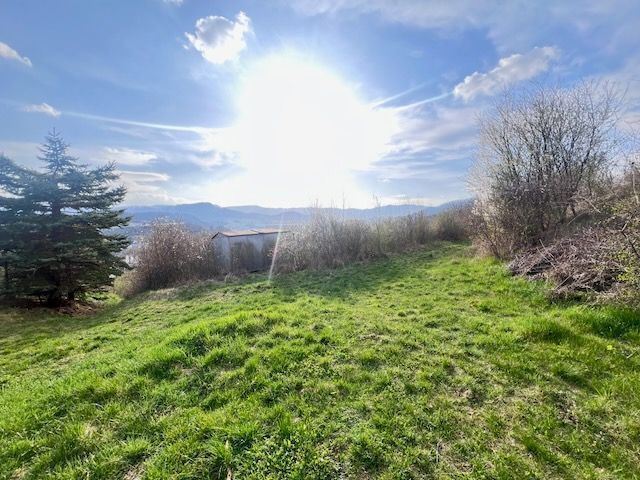 Green plot in Azalkova, Banska Bystrica surrounded by nature and blue sky.