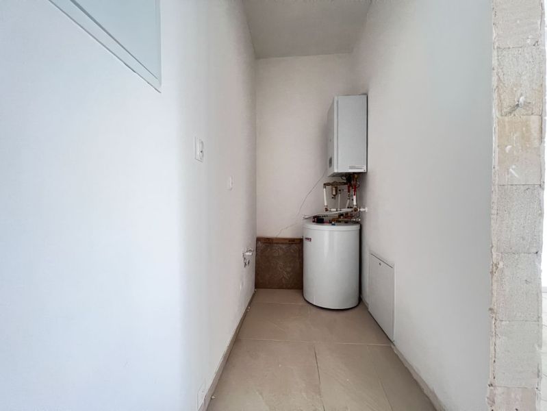Technical room in commercial premises with a boiler and a tank-mounted heater.