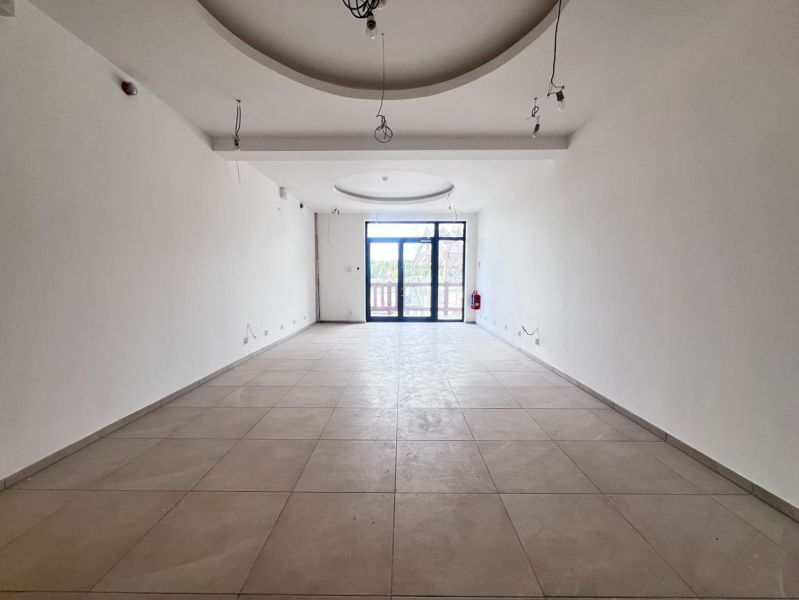 Interior of a commercial space with a window and white walls.