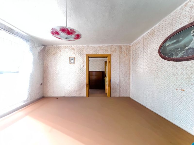 A room in a family house with a decorated chandelier and a floral pattern on the wall.