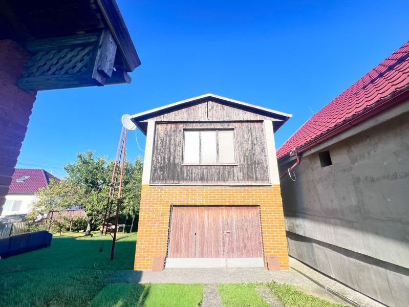 Family house in Žirany with a brick garage and wooden decor in the garden.