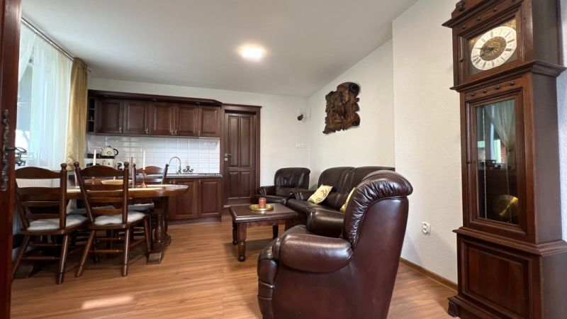 The interior of the villa with wooden floor decor, leather furniture, and a tiled stove.