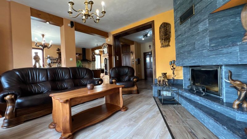 Leather sofa set and fireplace, floor with wood decor, elegant interior of the villa.