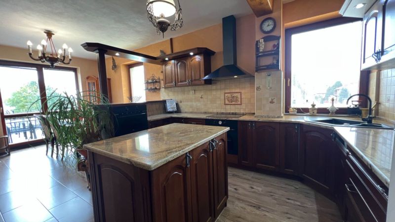 The villa's kitchen with wooden decor, floor with wooden design, spacious windows.