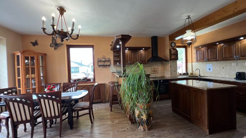 Wooden furniture in the kitchen with a wood-patterned floor and a large window.