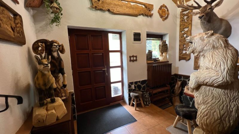 The interior of the villa with wooden animal sculptures and carved decorations on the walls.