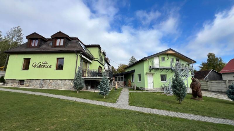 Villa in Štôla, Poprad District, Prešov Region, Slovakia, with a green facade and a meticulously maintained garden.