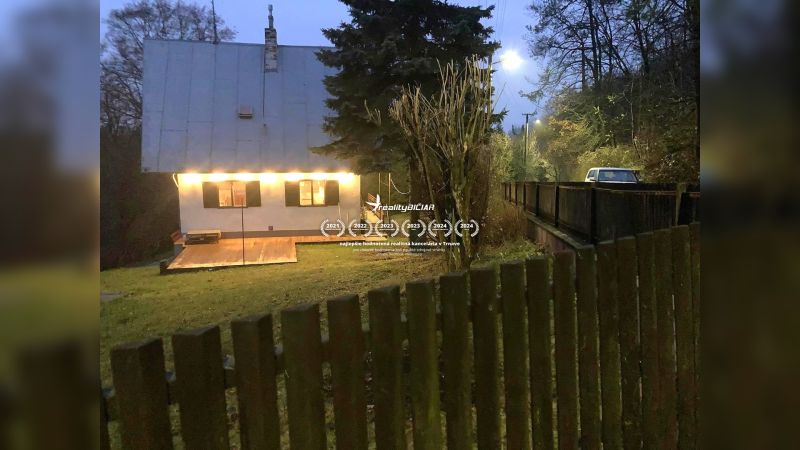 A family house in Horné Otrokovce on Horné Otrokovce Street with a lit terrace and gate.
