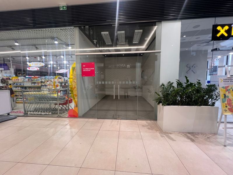 Commercial spaces with glazing and plants, next to the drugstore in the shopping center.