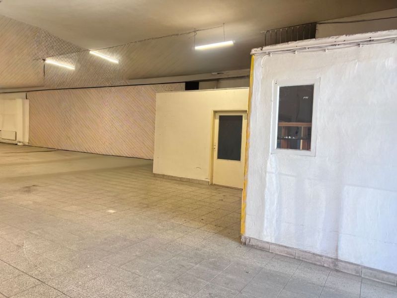Warehouse and hall spaces with tiled floors and white walls, ideal for storage.
