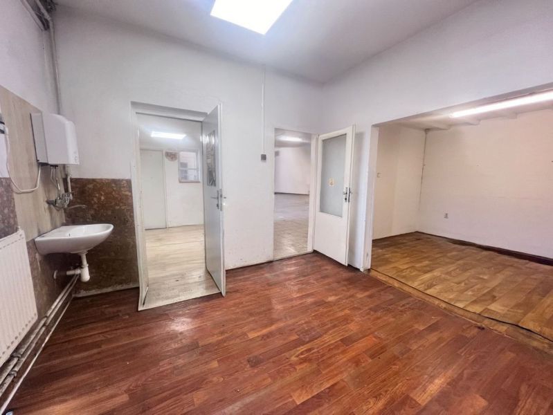 Interior of a warehouse and hall with a wooden decor floor and a sink on the wall.