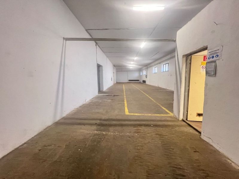 Interior of warehouses and halls with yellow lines on the floor, white walls, energy-efficient lighting.