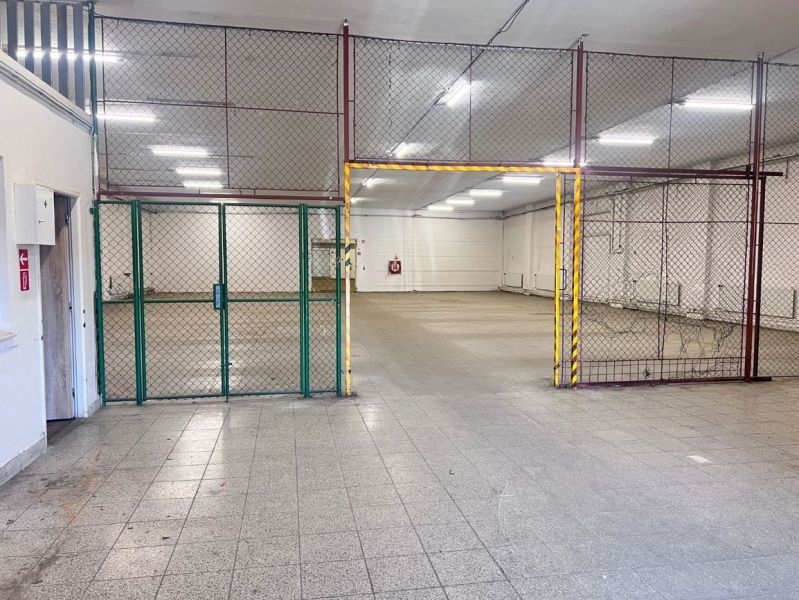 Interiors of warehouses and halls with tiling and metal fencing.