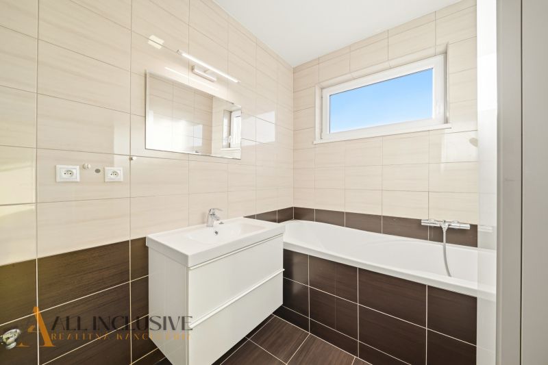 Bathroom with a shower in a 3-room apartment with tiles and a sink.
