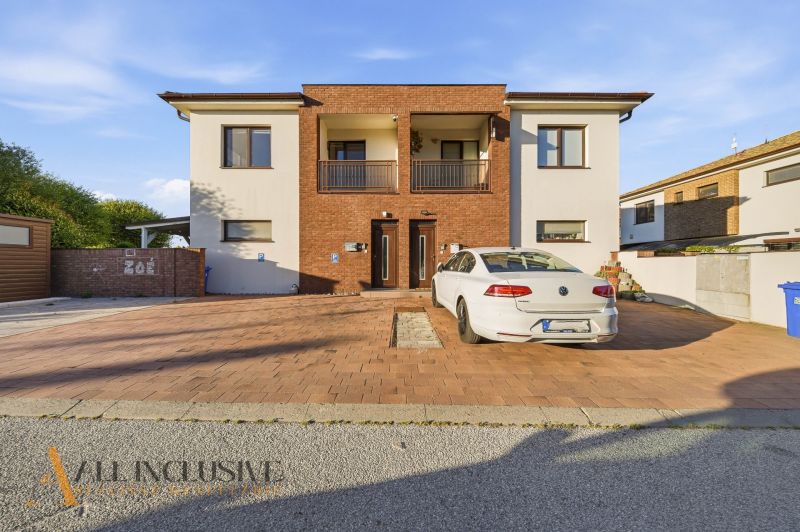 A family house with a brick facade and a parked car in Dunajská Streda in front of a 3-room apartment.