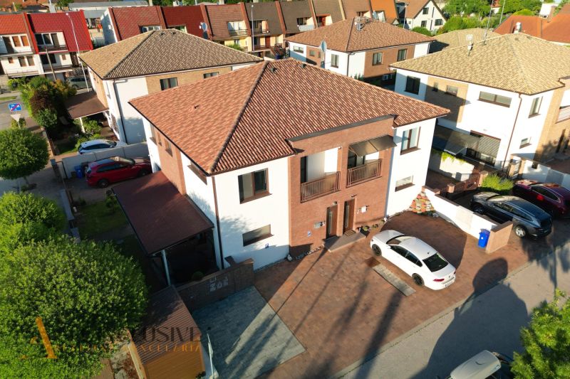 In Dunajská Streda, modern houses with a parking lot in front of the entrance are displayed.