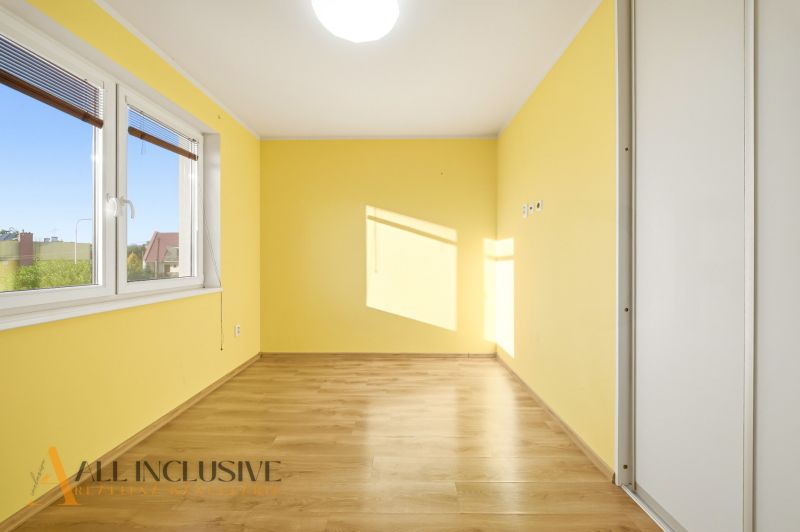 Interior of a 3-room apartment with yellow walls and a floor with a wooden decor.