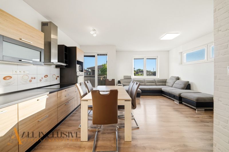 3-room apartment with a kitchen, living room, wooden decor flooring, and a large window.